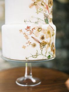 a wedding cake decorated with flowers on a table