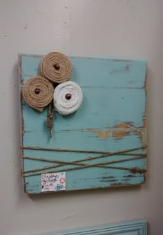 two rolls of twine are tied to a piece of wood on the wall above a radiator