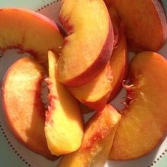 sliced peaches sitting on top of a white plate