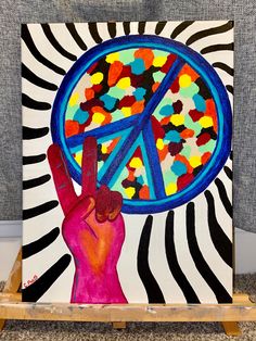 a painting with a peace sign painted on it's face and hand holding up the peace symbol