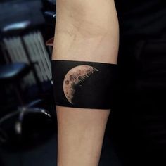 a man's arm with a half moon tattoo on it