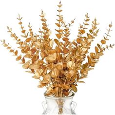 a vase filled with lots of gold colored leaves