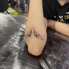 a person sitting at a table with a tattoo on their leg