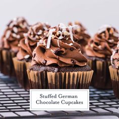 chocolate cupcakes topped with frosting and sprinkles on a cooling rack