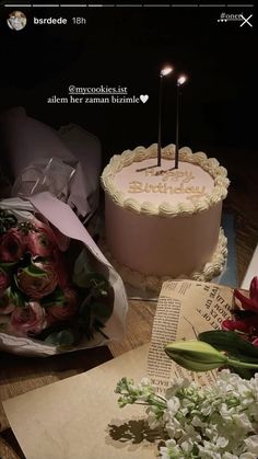 there is a cake with candles on it next to flowers and paper bags that say i love you