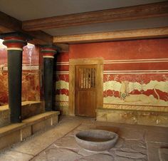 an empty room with columns and paintings on the walls