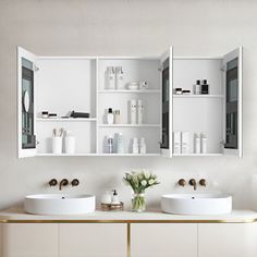 a bathroom with two sinks and mirrors on the wall next to shelves filled with personal care items