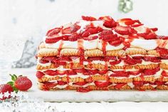 strawberry shortcakes stacked on top of each other with whipped cream and strawberries