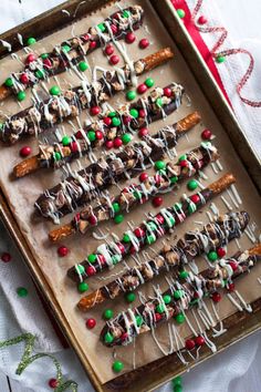 christmas pretzels are arranged on a baking sheet with candy and sprinkles