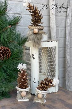 two pine cones are sitting on top of a white box next to some pine cones