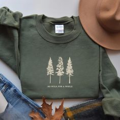 Embrace the spirit of adventure with our Pine Tree Sweatshirt featuring the phrase "Go Wild, For a While" and a stunning graphic. Perfect for nature lovers, this hiking and camping crewneck makes an ideal gift for granola girls and travel enthusiasts who crave the great outdoors and the freedom of the wilderness. Prefer this design on a T-Shirt? Visit this link: https://bohemianbloomdesigns.etsy.com/listing/1772284433 Prefer this design on a Hoodie? Visit this link: https://bohemianbloomdesigns. Outdoorsy Shirt, Bleaching Clothes, Outdoorsy Style, Hiking And Camping, Music Festival Outfits, Coffee Sweatshirt, Mama Style, Granola Girl, Fun Sweatshirts