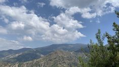 the mountains are covered with trees and clouds