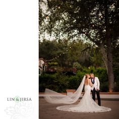 a bride and groom pose for their wedding photo in front of the trees at sunset