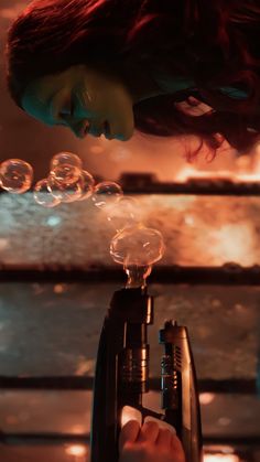 a woman blowing bubbles on top of a machine