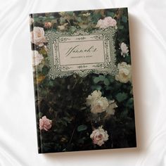 a book that is sitting on top of a white bed sheet with pink and white flowers