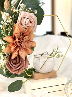 a vase filled with flowers sitting on top of a table next to a book and candle