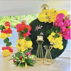 an arrangement of balloons and flowers on display