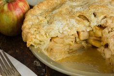 an apple pie sitting on top of a metal plate