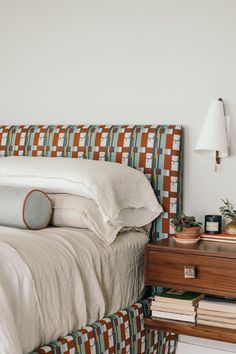 a bedroom with a bed, nightstand and lamp