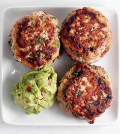 three crab cakes on a plate with guacamole