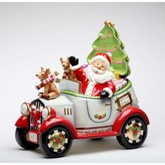 a santa clause riding in a firetruck with reindeers on the side and a christmas tree