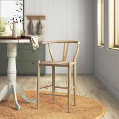 a wooden chair sitting on top of a rug next to a table