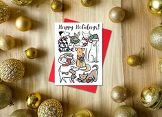 a happy holidays card surrounded by christmas ornaments and gold baubles on a wooden surface