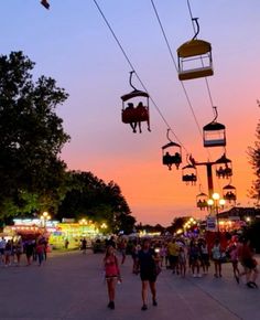 many people are walking down the street at dusk with their ski lifts above them