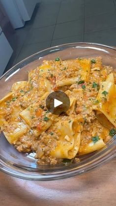 a glass bowl filled with pasta and sauce