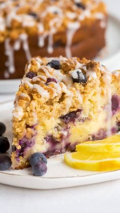 a slice of blueberry crumb cake on a plate with lemon wedges next to it