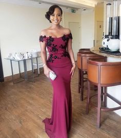 a woman in a purple dress standing next to a table