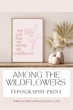 the wildflowers typograph print is displayed on a shelf next to a potted plant