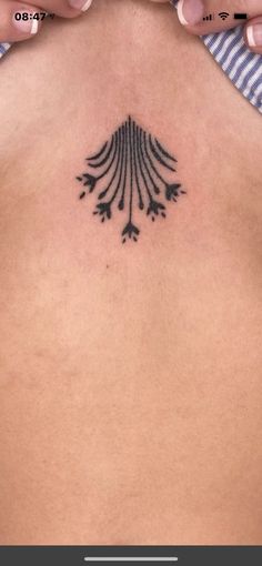 a woman's back with a tattoo design on her left side ribcage