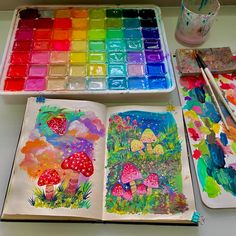 an artist's desk with paint and watercolors on it