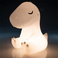 a light that looks like a dinosaur sitting on the ground with it's eyes closed