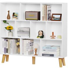 a white book shelf with books and vases on it's sides, along with other decorative items