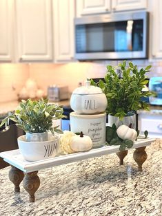 the kitchen counter is covered with white dishes and plants on it's trays