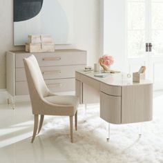 a desk with a chair and a vase on it in front of a large window