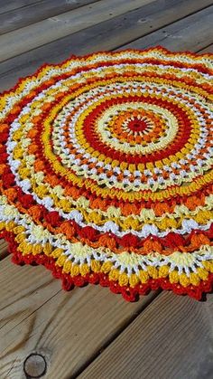 a multicolored round rug is sitting on a wooden floor with wood planks