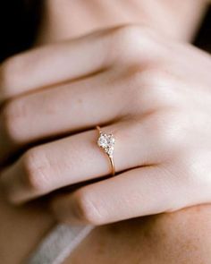 a woman's hand with a diamond ring on it