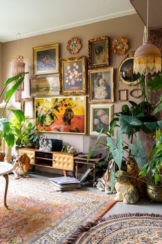 a living room filled with lots of plants and pictures