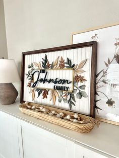 two framed pictures on top of a white dresser