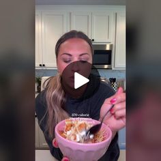 a woman holding a bowl of food in her hands and eating it with a spoon