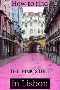 the pink street in lisbon has been dyed with purple paint and is surrounded by tall buildings