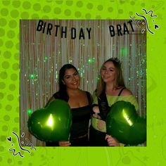 two women standing next to each other holding green balloons