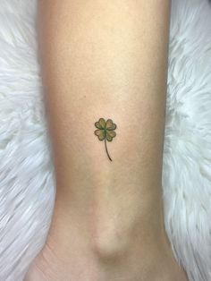 a small four leaf clover tattoo on the right side of the leg, it's green