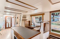 the inside of a house with wood flooring and white walls, windows, and cabinets