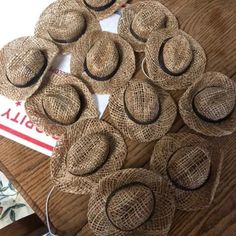 several straw hats are arranged in a circle on a wooden table next to other items