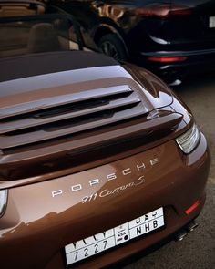 two porsches parked next to each other in a parking lot with their license plates