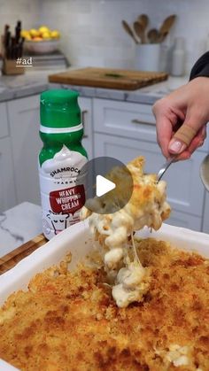 a person scooping some food out of a casserole dish